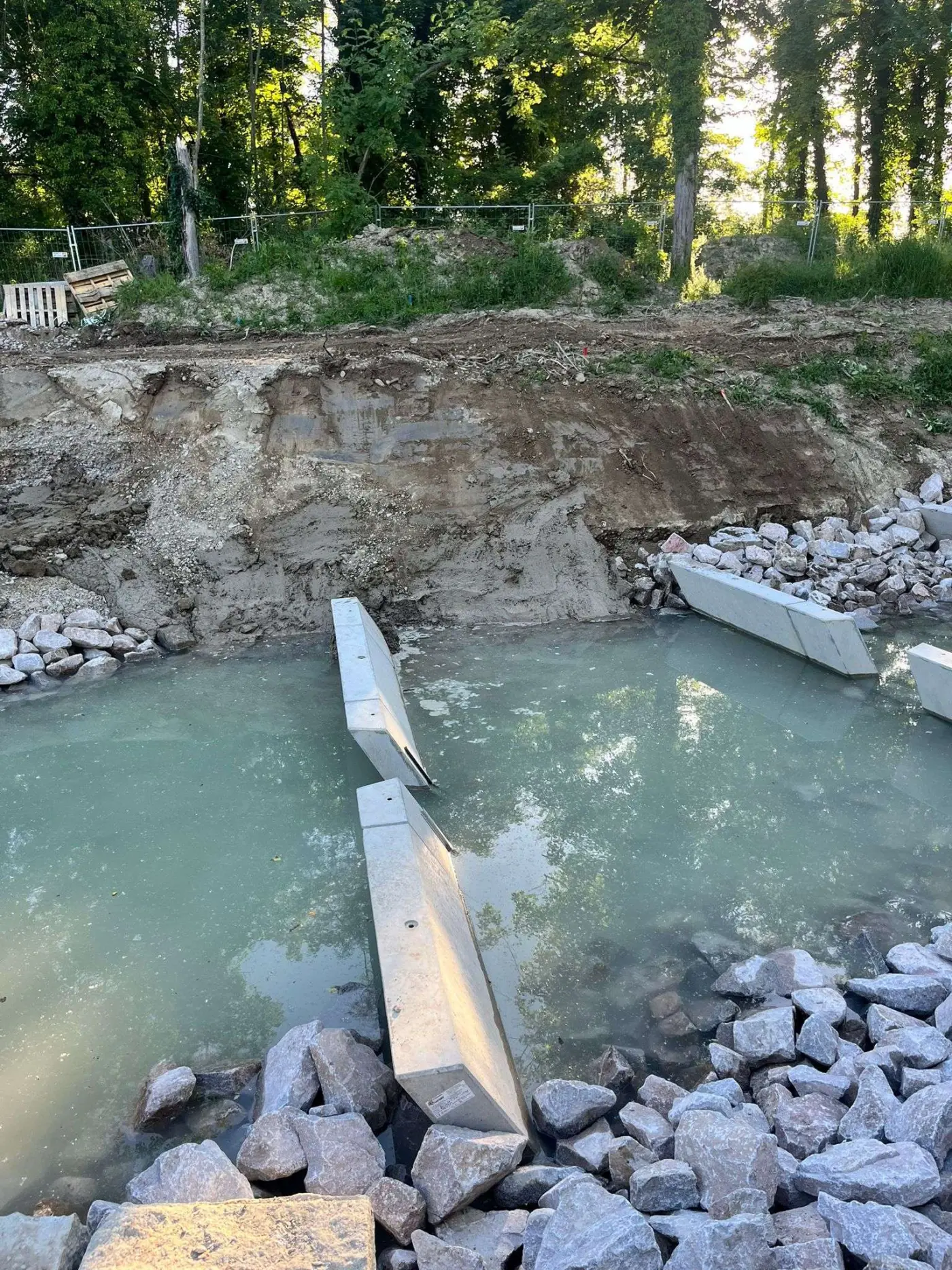Sohlensicherung mit Betonelementen die in Flüssigboden Flussbett gesetzt wurden