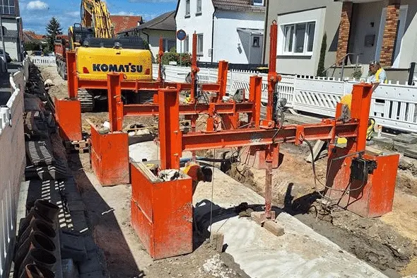 Rohrgraben in der Ortsdurchfahrt mit Verbau und gesetzten RSS Rohrverlegehilfen nach der Verfüllung vor lastverteilnder Platte