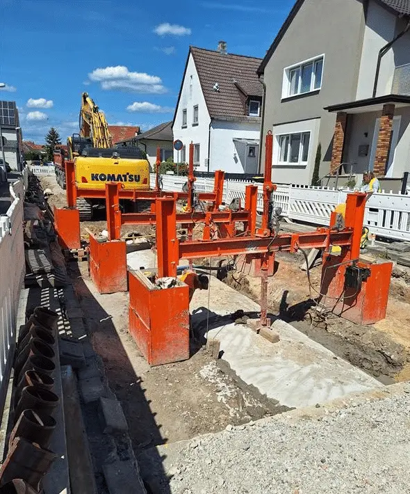 Rohrgraben in der Ortsdurchfahrt mit Verbau und gesetzten RSS Rohrverlegehilfen nach der Verfüllung vor lastverteilnder Platte