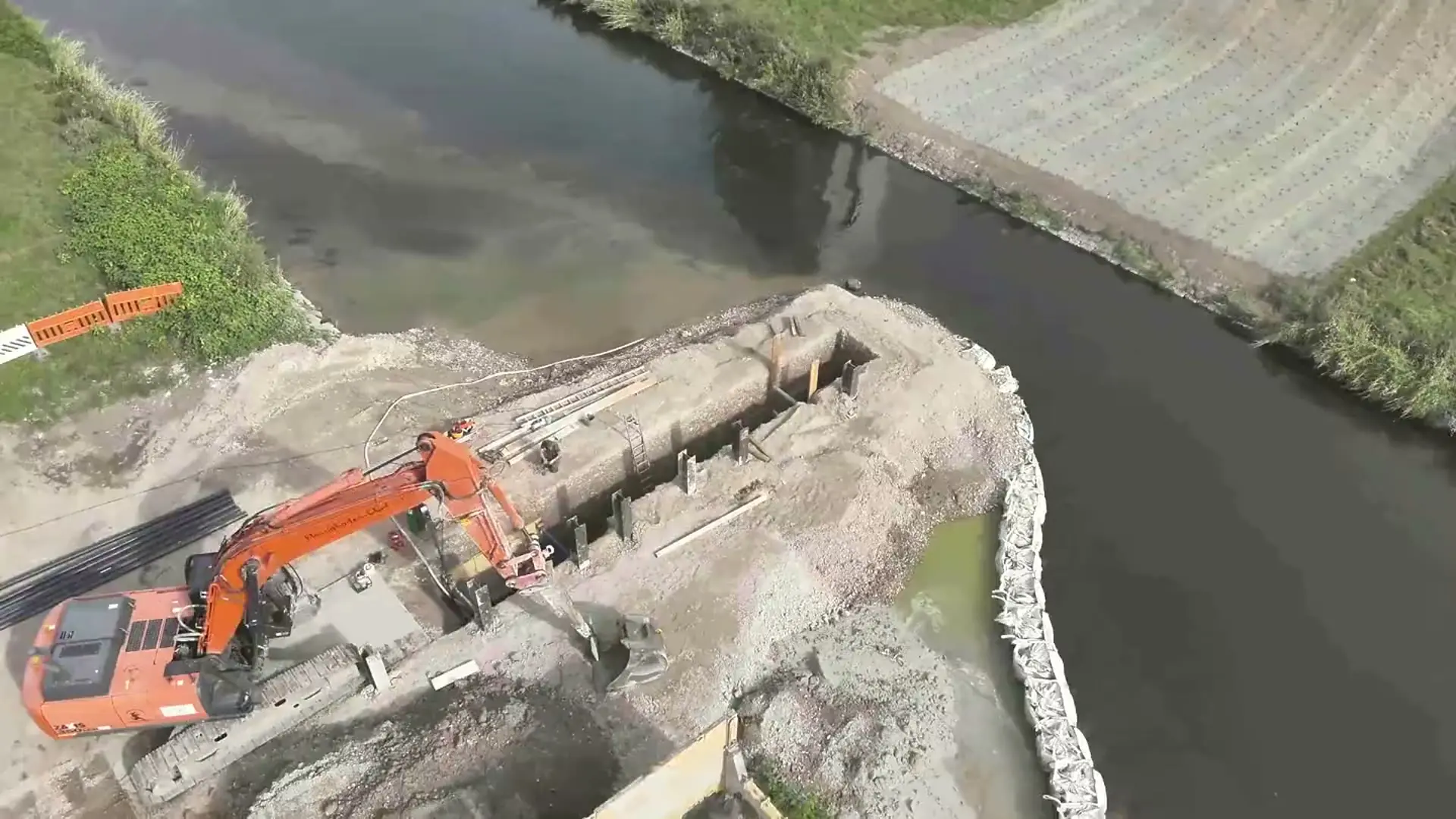 Baustelle am Fluss mit Bagger – Flüssigboden Engineering