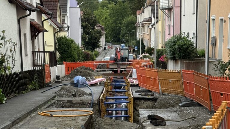 Leitungsbau in innerstädtischer Straße mit Verbaukasten und enger Arbeitszone, die Baugrube wird für die Verfüllung mit Flüssigboden vorbereitet