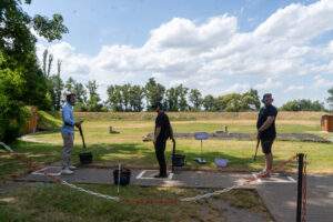 Drei Angestellte von Flüssigboden Engineering stehen an der Station zum Tontauben schießen