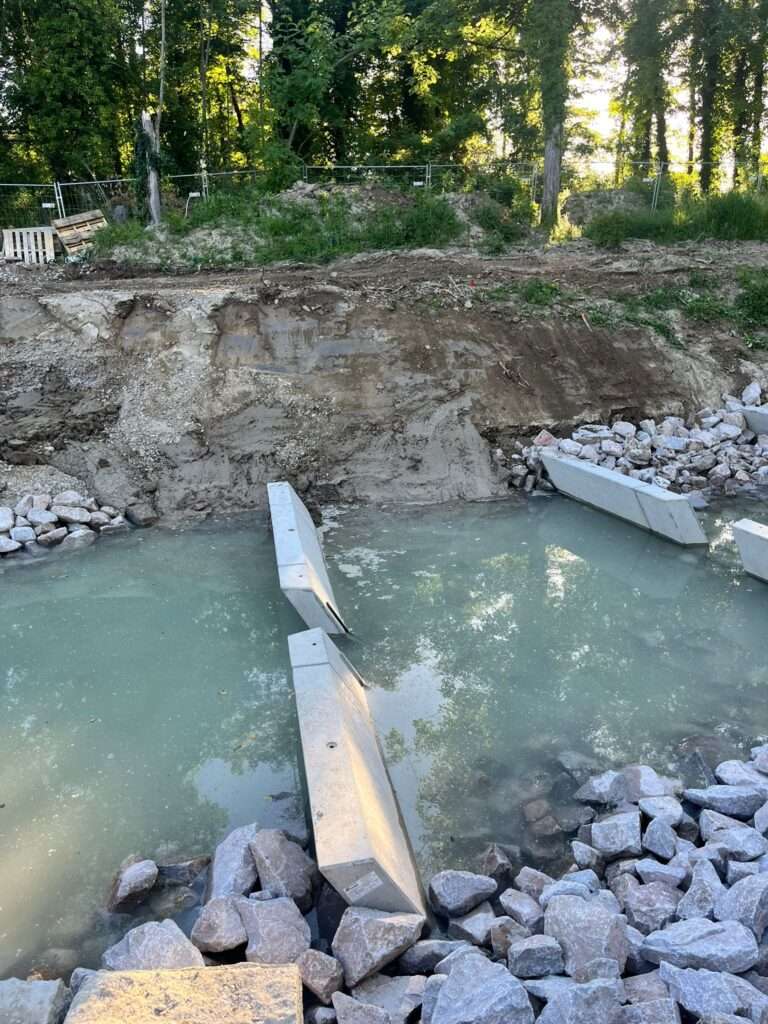 Sohlensicherung mit Betonelementen die in Flüssigboden Flussbett gesetzt wurden