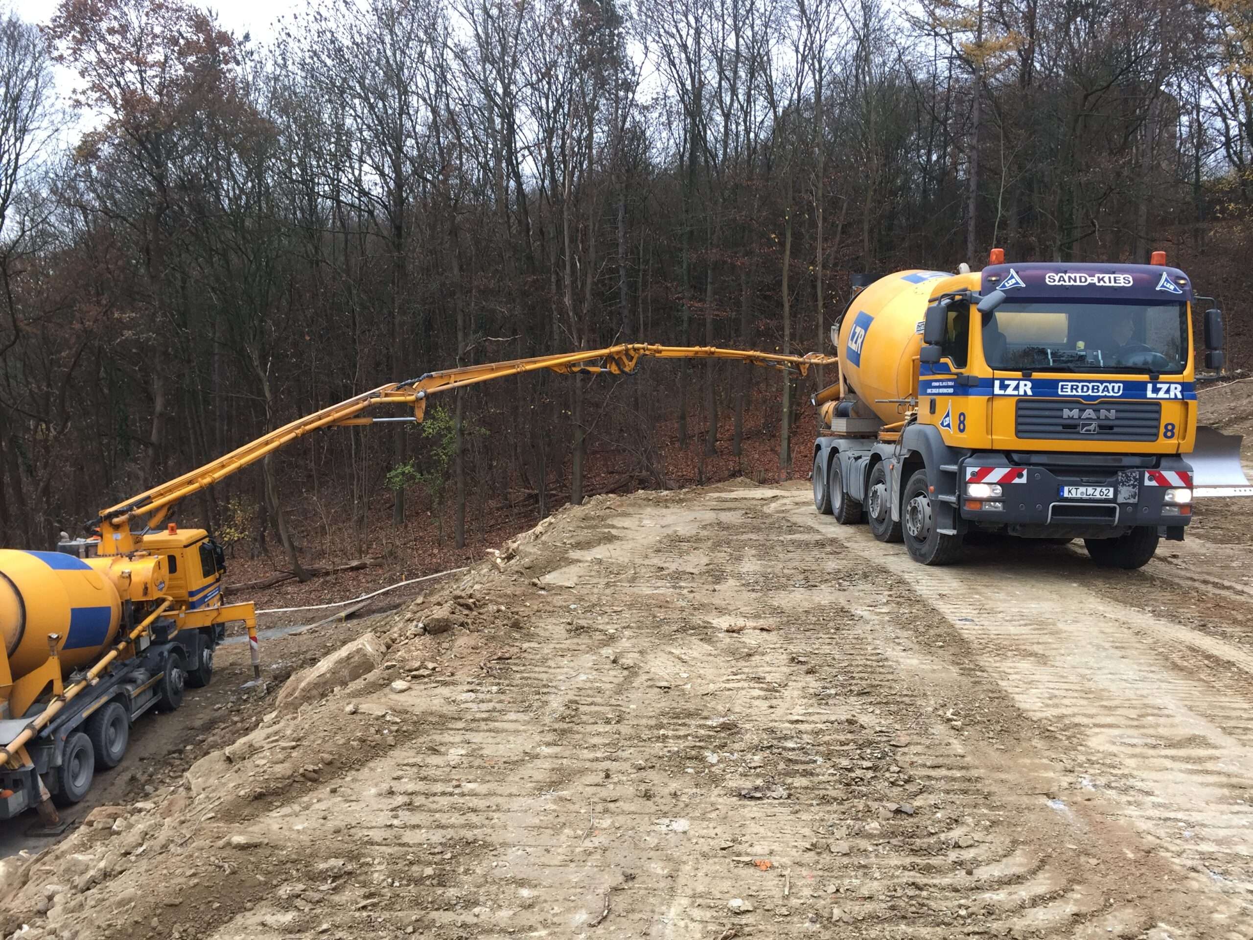Fahrmischer und Betonpumpe am Hangfuß - Übergabe des Flüssigbodens an die Pumpe