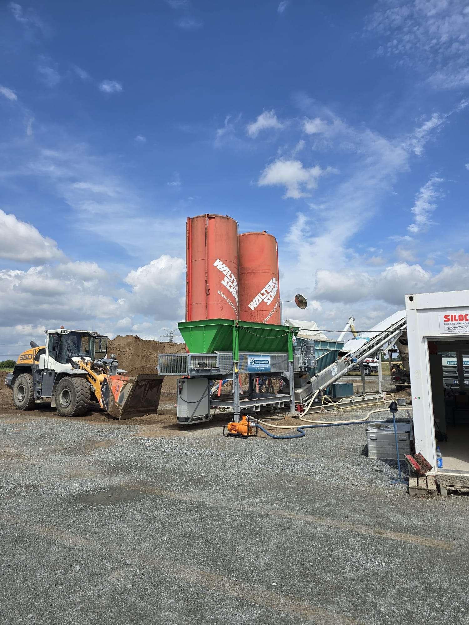 Herstellung Flüssigboden in mobiler Mischanlage mit Zementsilos Aufgabetrichter und Laborcontainer vor Ort