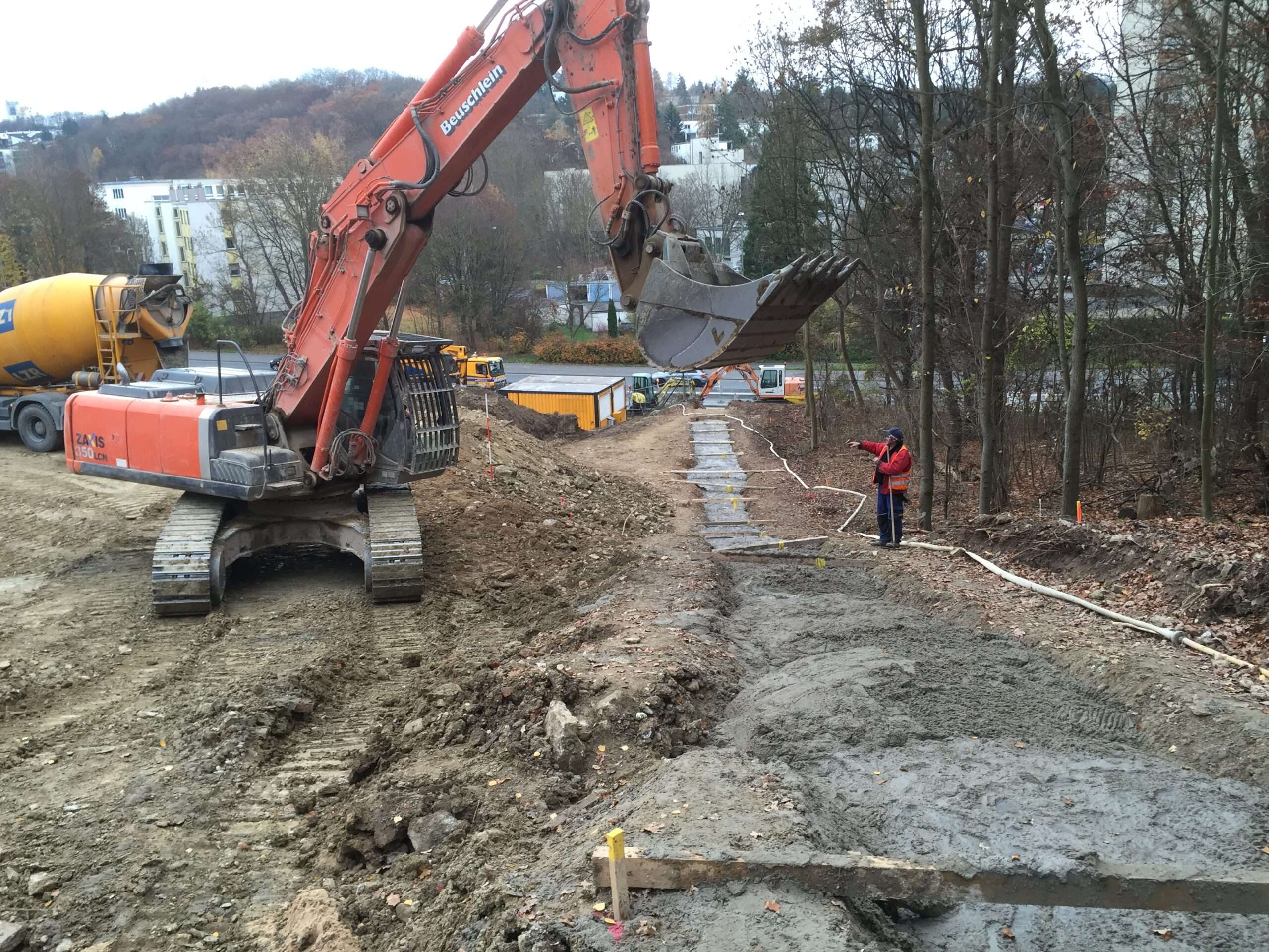 Bagger verfüllt Zwischenbereiche der Hangtrasse nach dem Umsetzen der Pumpe