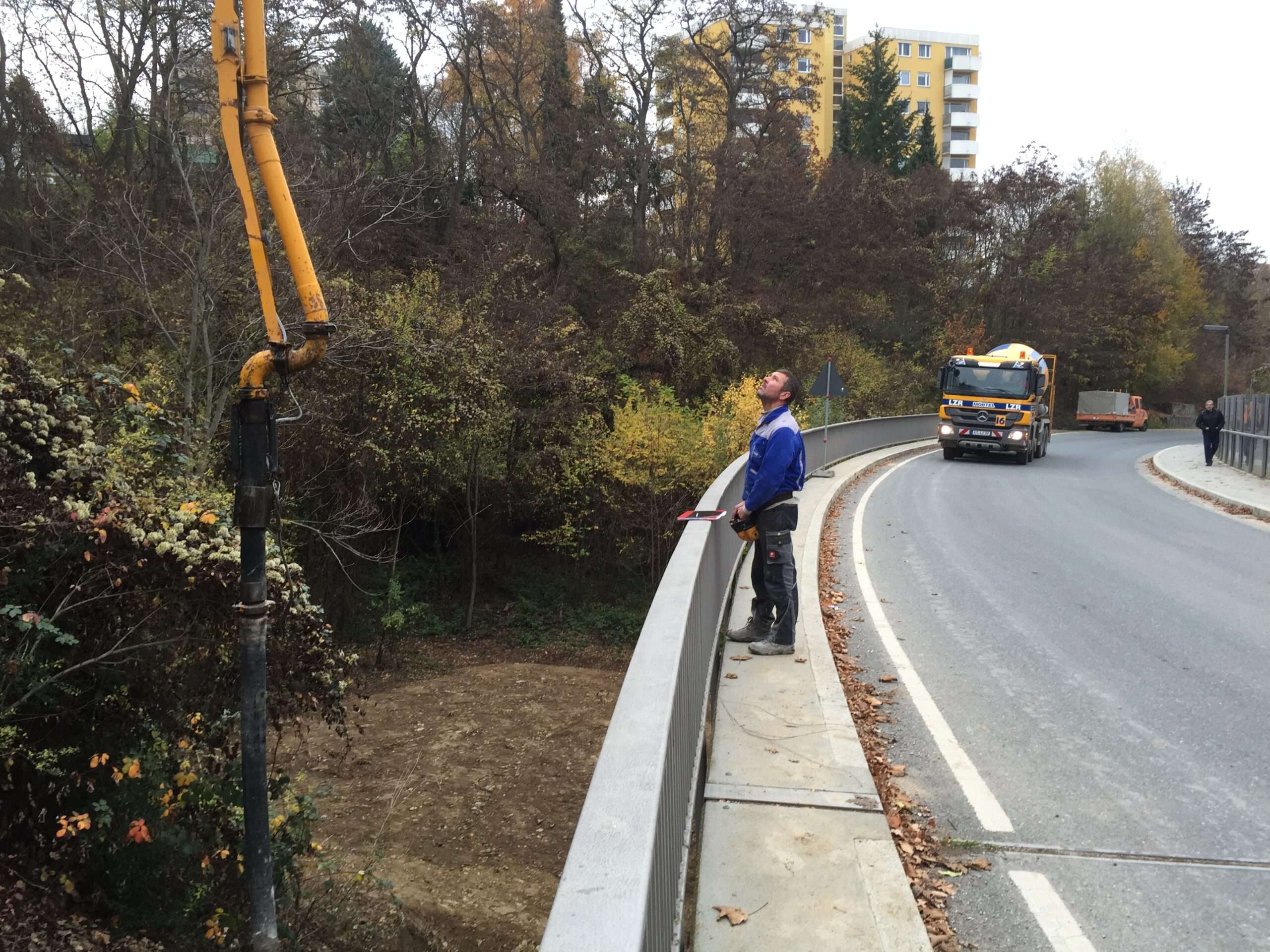 Betonpumpe auf der Brücke - Mast über das Brückengeländer in den Steilhang